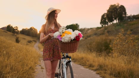 Mädchen-Im-Mittleren-Plan-Im-Kleid-Geht-Mit-Fahrrad-Und-Blumen-Auf-Dem-Feld